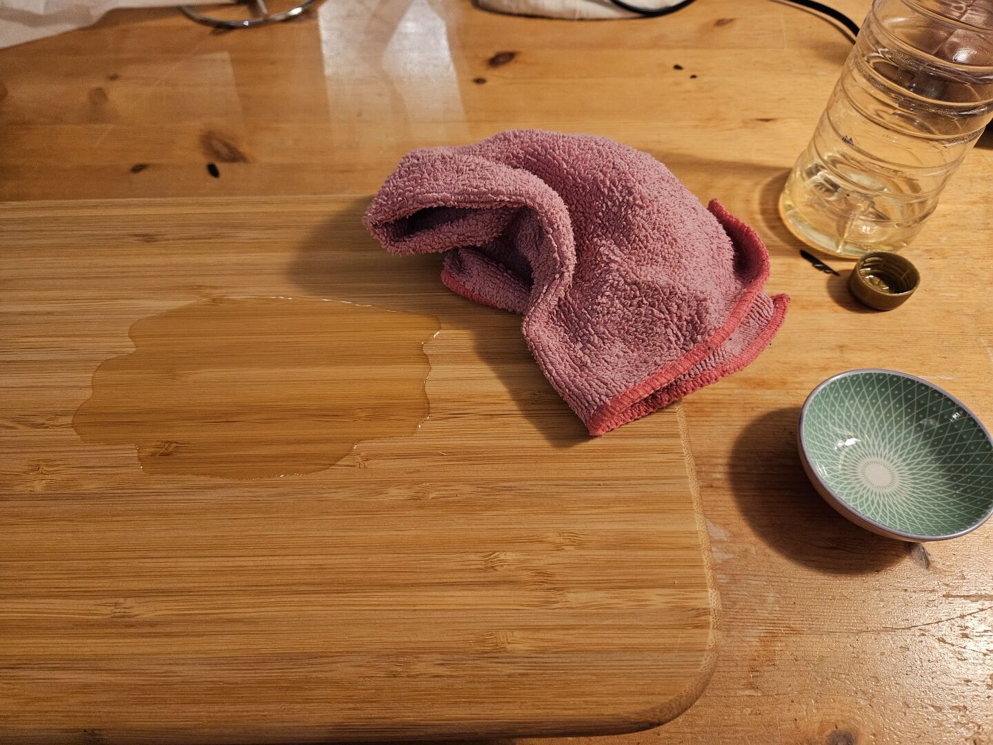 A cutting board where I put a pool of cannola oil and a cloth to spread it out.