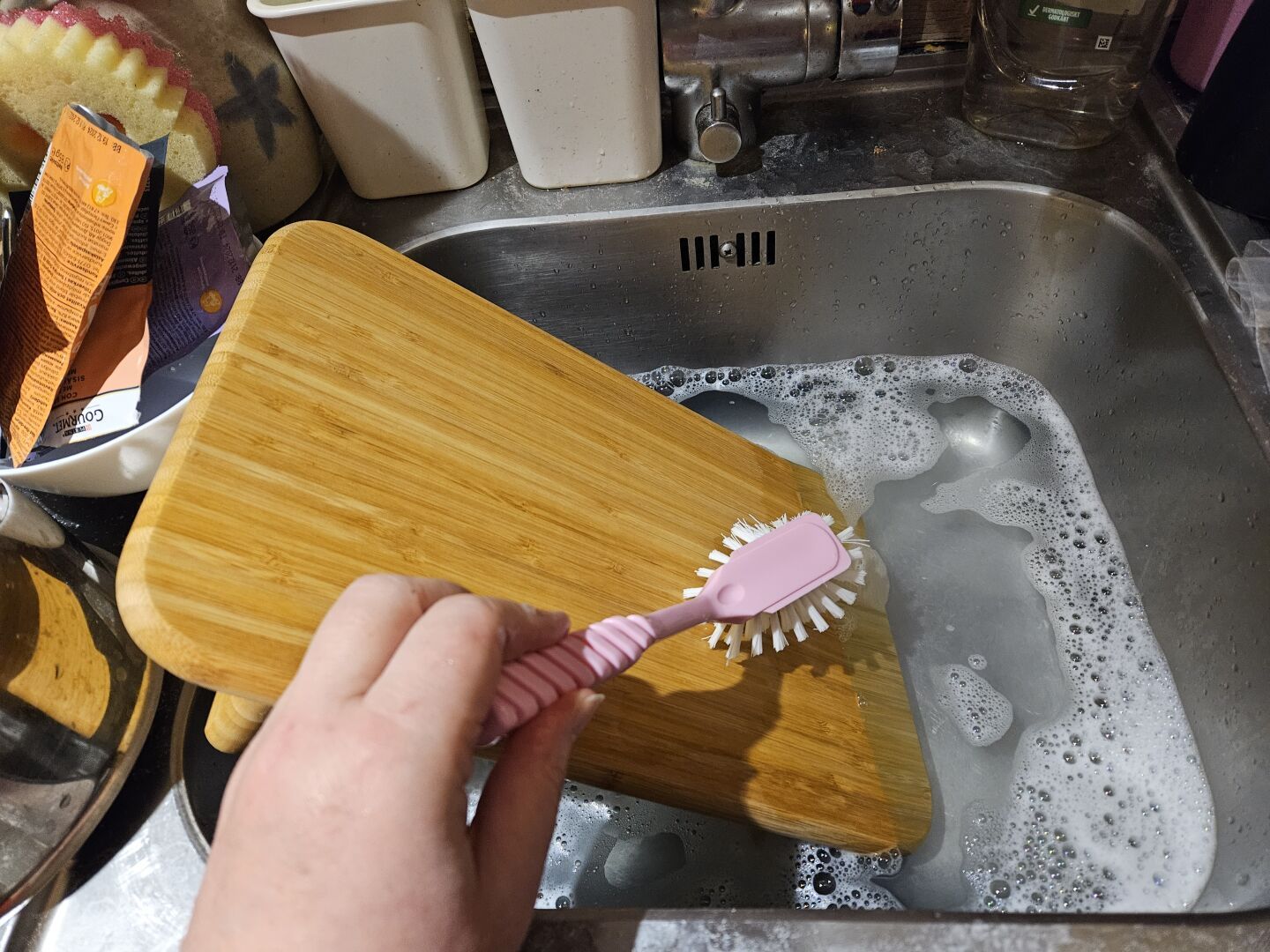 One of the cutting boards being washed in a sink.