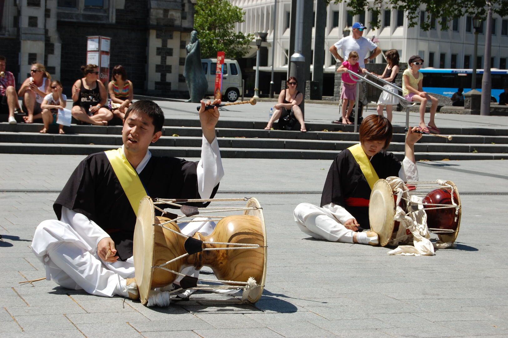 2 Mönche, auf dem Boden sitzend mit hölzernen Trommel