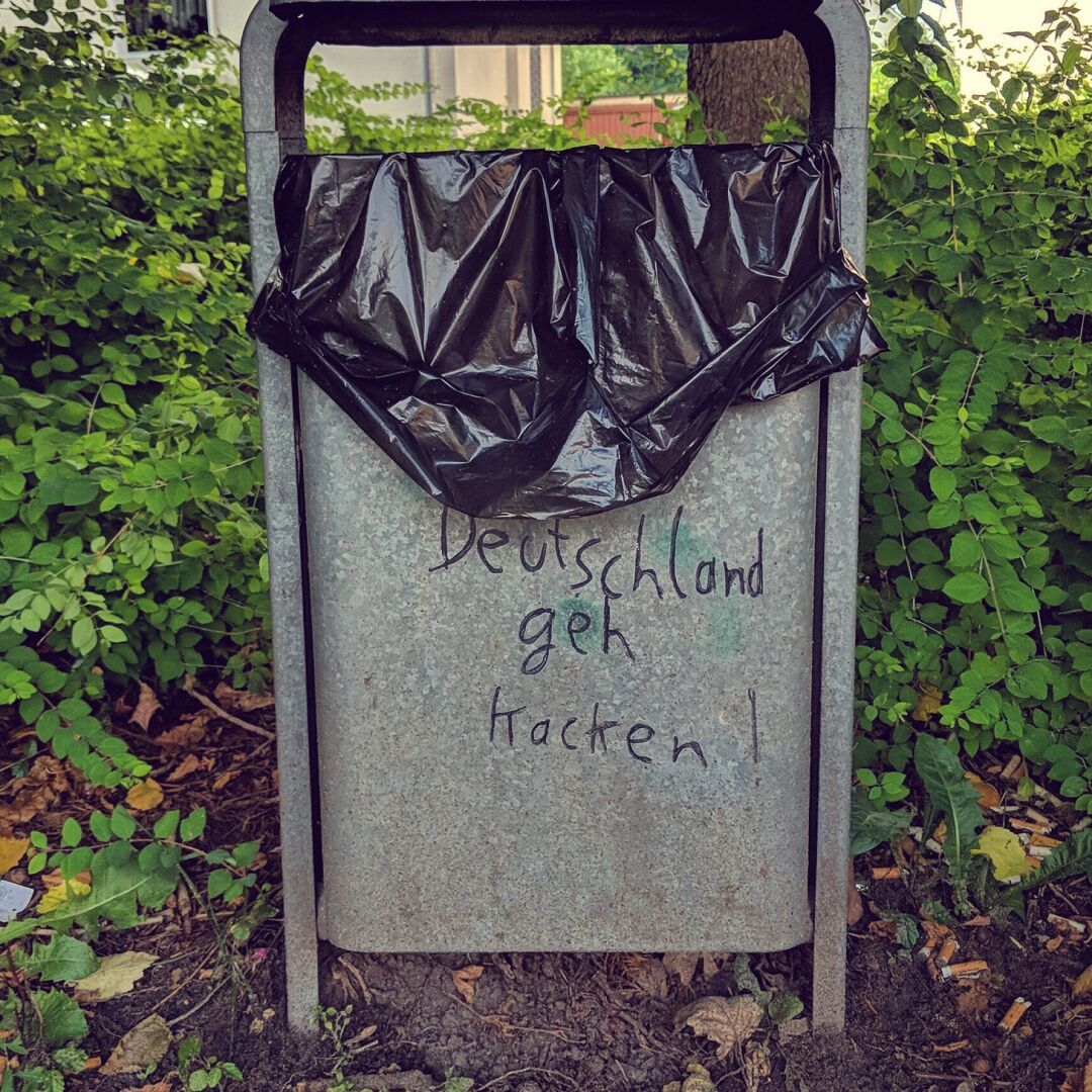A trash can on which someone has written: "Deutschland geh kacken!"