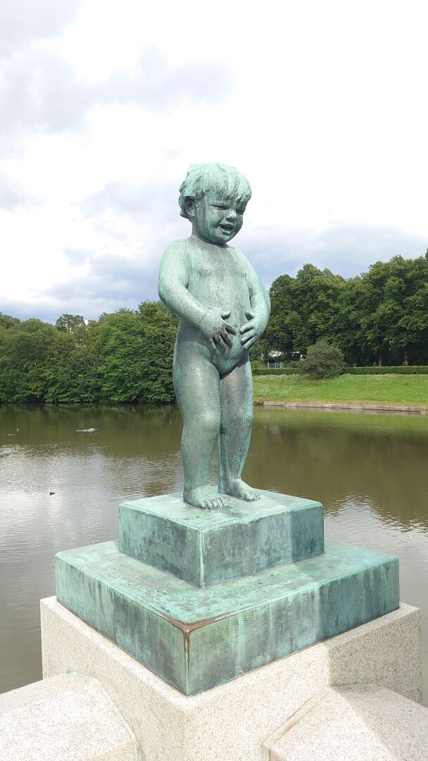 Statue of a naked child. She's holding her belly laughing.