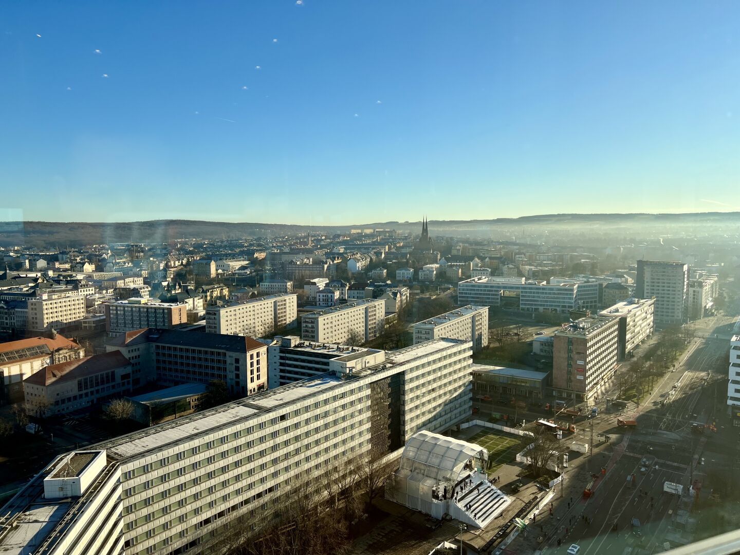 Ausblick über die Dächer der Stadt Chemnitz. Unten an der Straße vor einem Wohnblock wurde eine bühne aufgebaut, die das dort stehende Karl-Marx-Monument umhüllt.