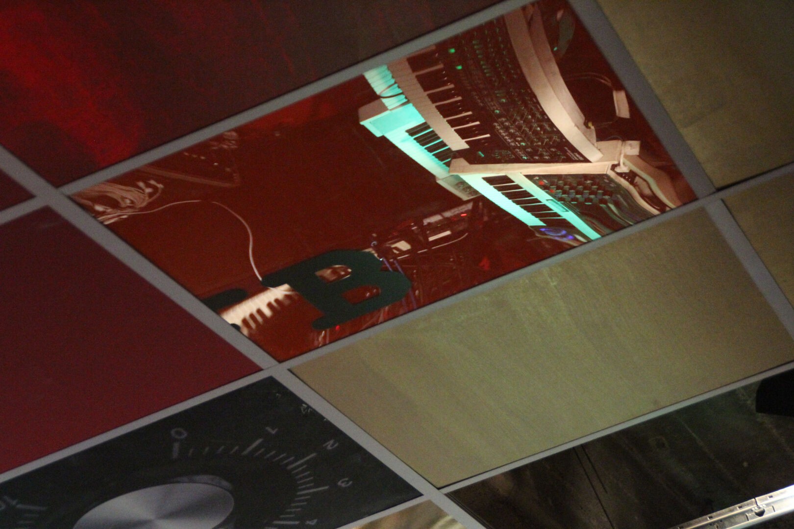 Shot at the ceiling of the same showroom as before, in a reflection more of Thorsten Quaeschnings rig can be seen: a Roland System-8 and a Moog Voyager synthesizer, and the Mellotron reincarnation Memotron. About the Memotron he said, it's phantastic since there is enough space to put more gear on top. Here he had a Moog Minitaur and some Delay Pedals mounted, but two more full size keyboards stacked on one another were no problem, including a Solina String machine