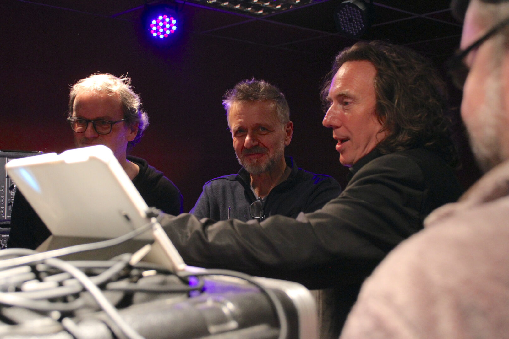 Synthesizer Museum Berlin host Michael Soltau to the left, Non Eric (of techno and Musotalk fame) in the middle and Thorsten Quaeschning to the right, looking at and talking about the latter's gear on stage.