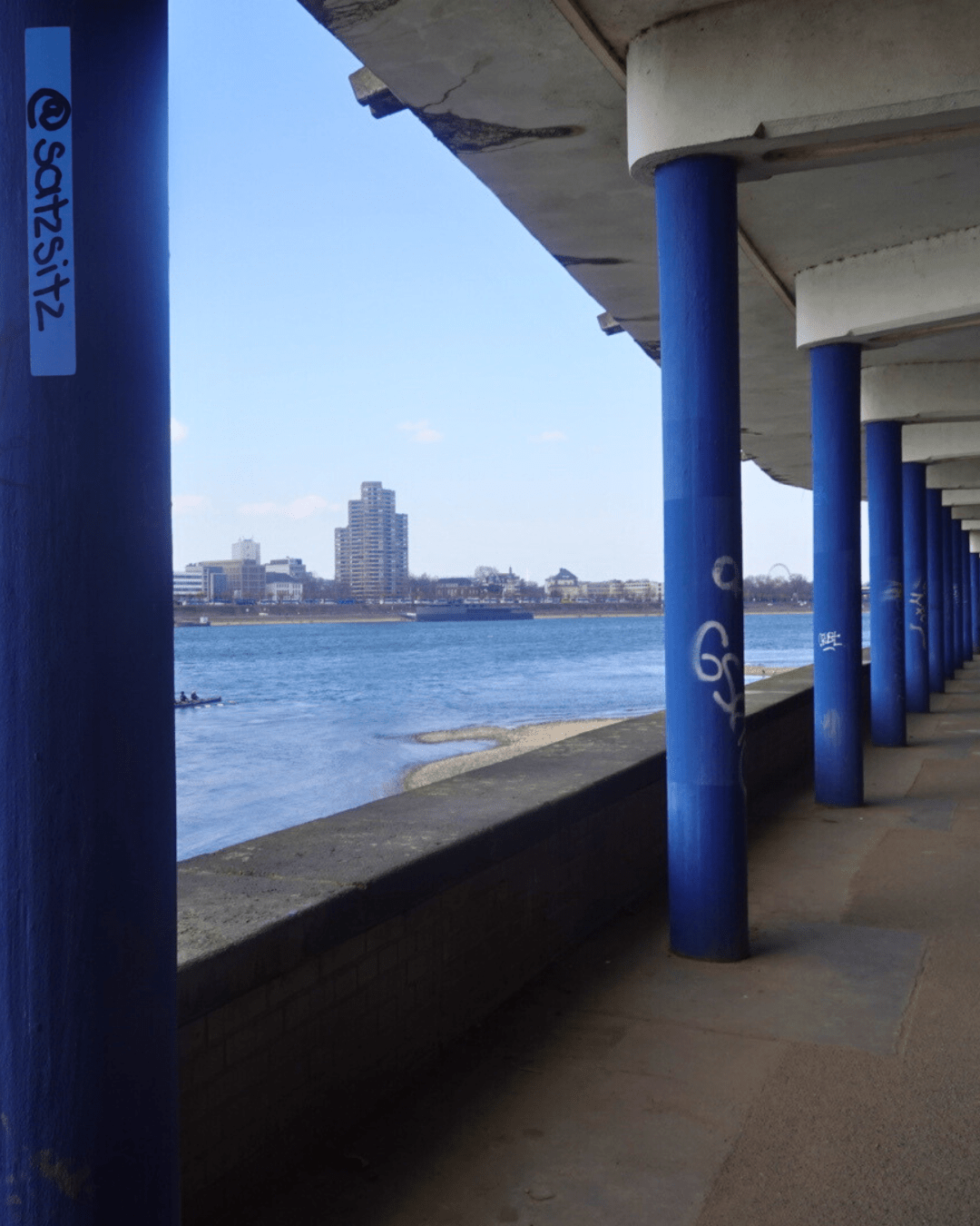 Betongang am Rhein mit blauen Säulen