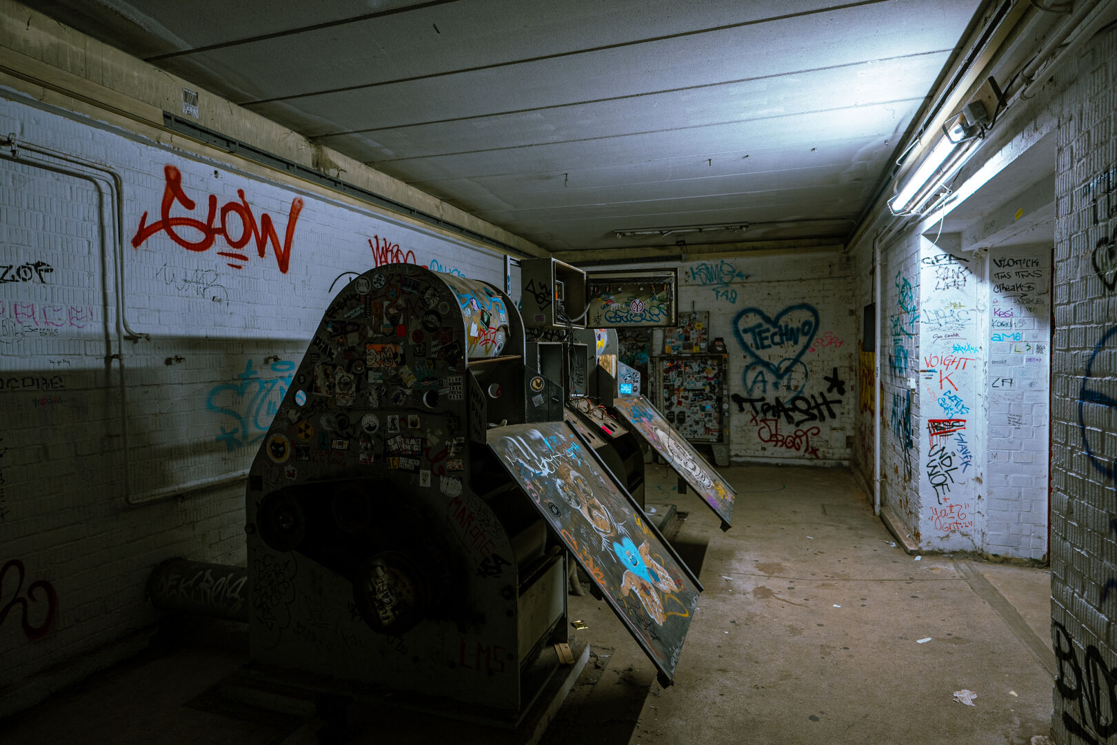 Inside the building, very moody lighting. Lost places vibe. Neon light lighting the room.