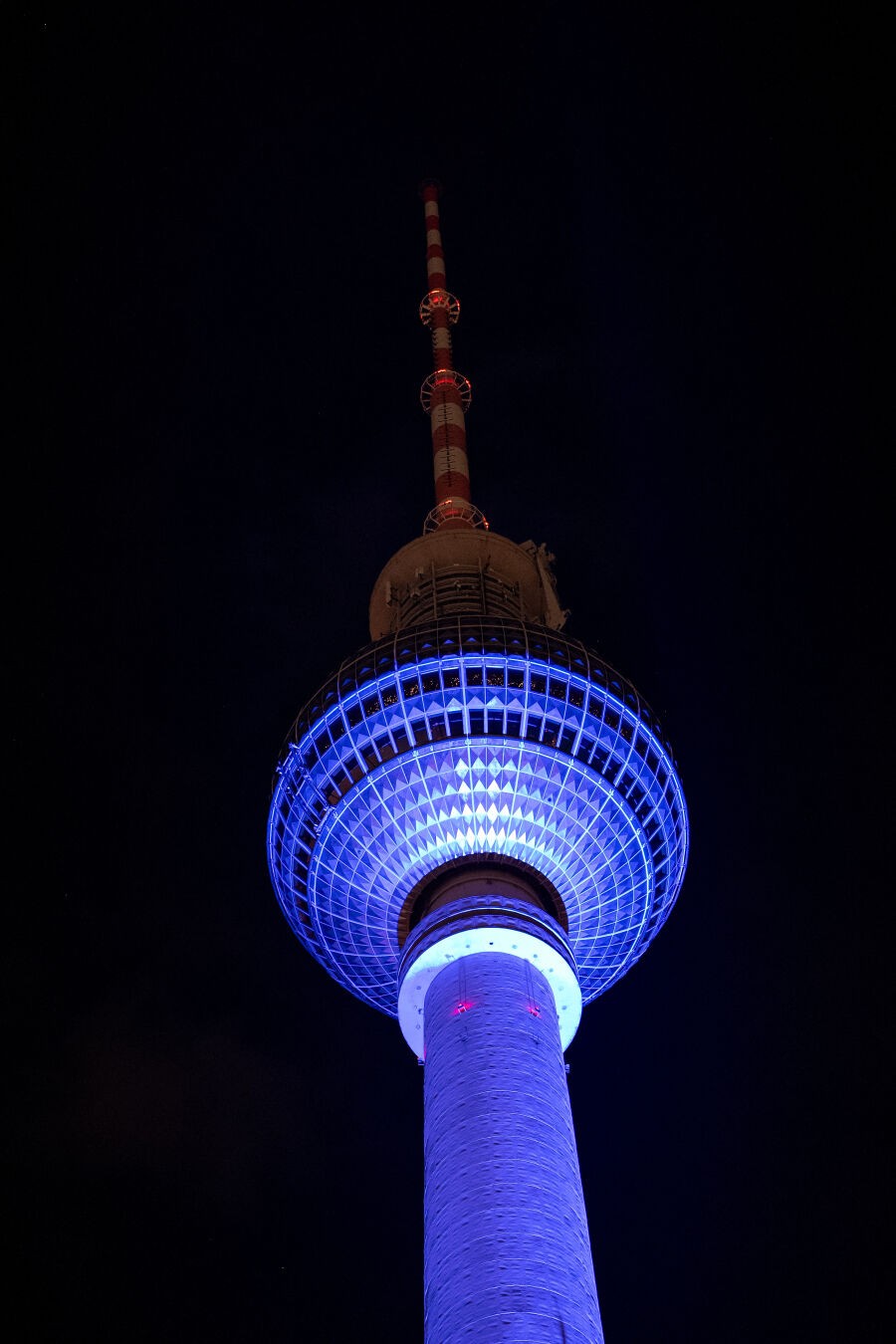 Berlin Fernsehturm (TV tower) at night during festival of lights. Its being lit in blue light.