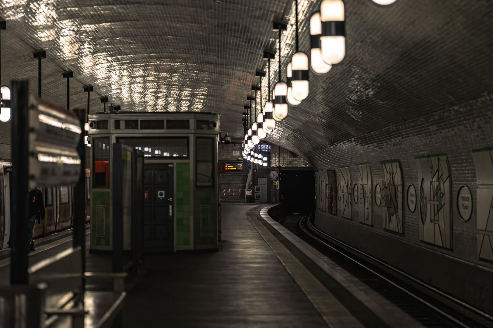 Artistic shot of a subway station in Berlin alongside the rails into a dark tunnel playing with perspective.