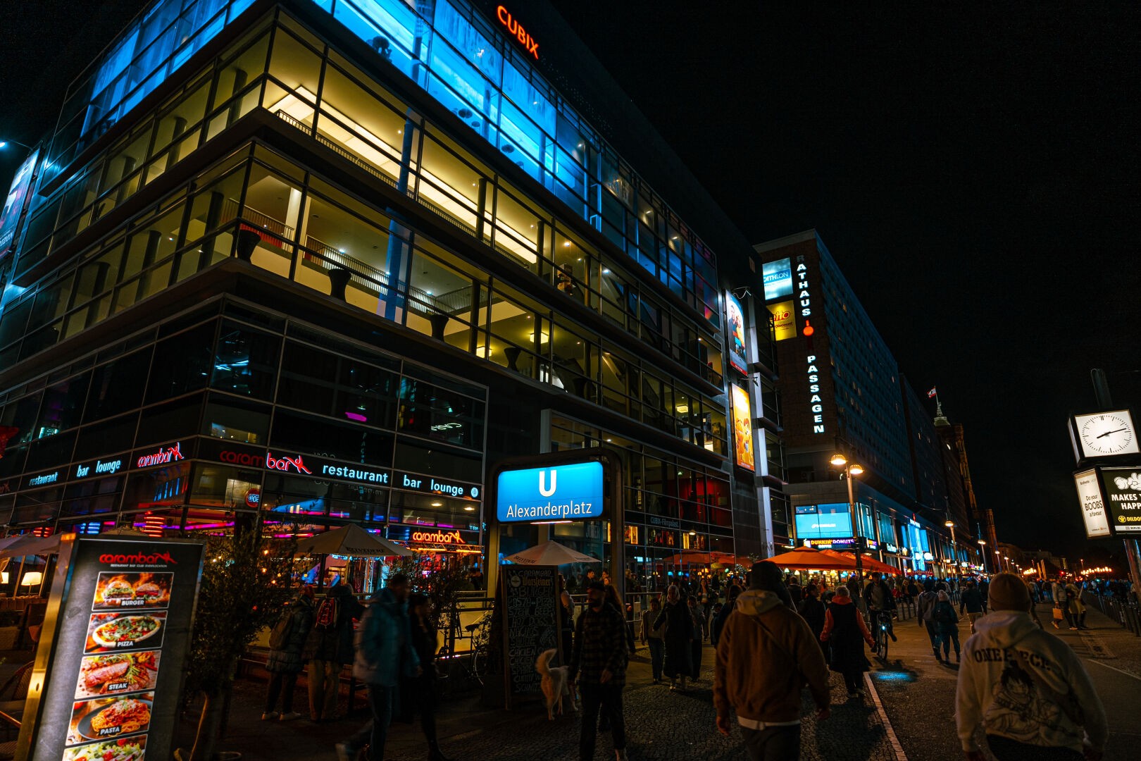 Low light image during night of a busy part close to Alexanderplatz with many restaurants and neon signs.