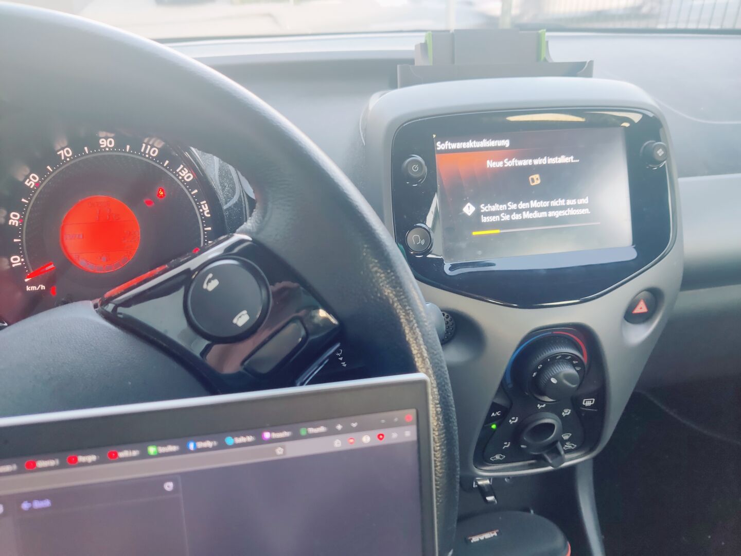 Photo of my car dashboard. the multimedia screen indicates that it is currently in the process of updating, with approx 20% completion