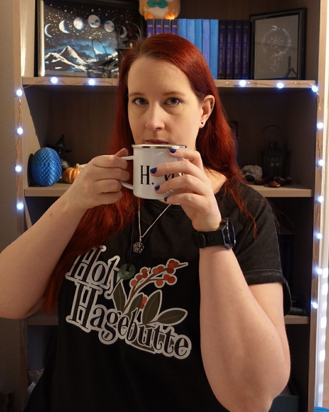 Ich halte eine Tasse in der Hand und gucke in die Kamera