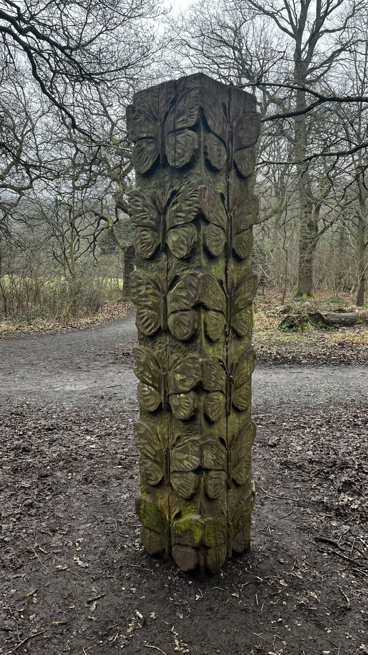A square wooden column, with a repeating Butterfly motif.